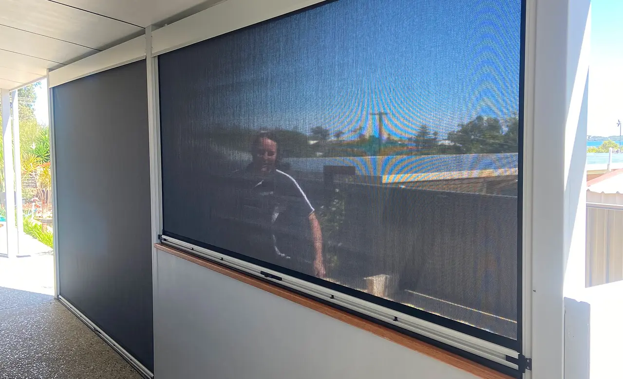 Outdoor patio with mesh screen shades.