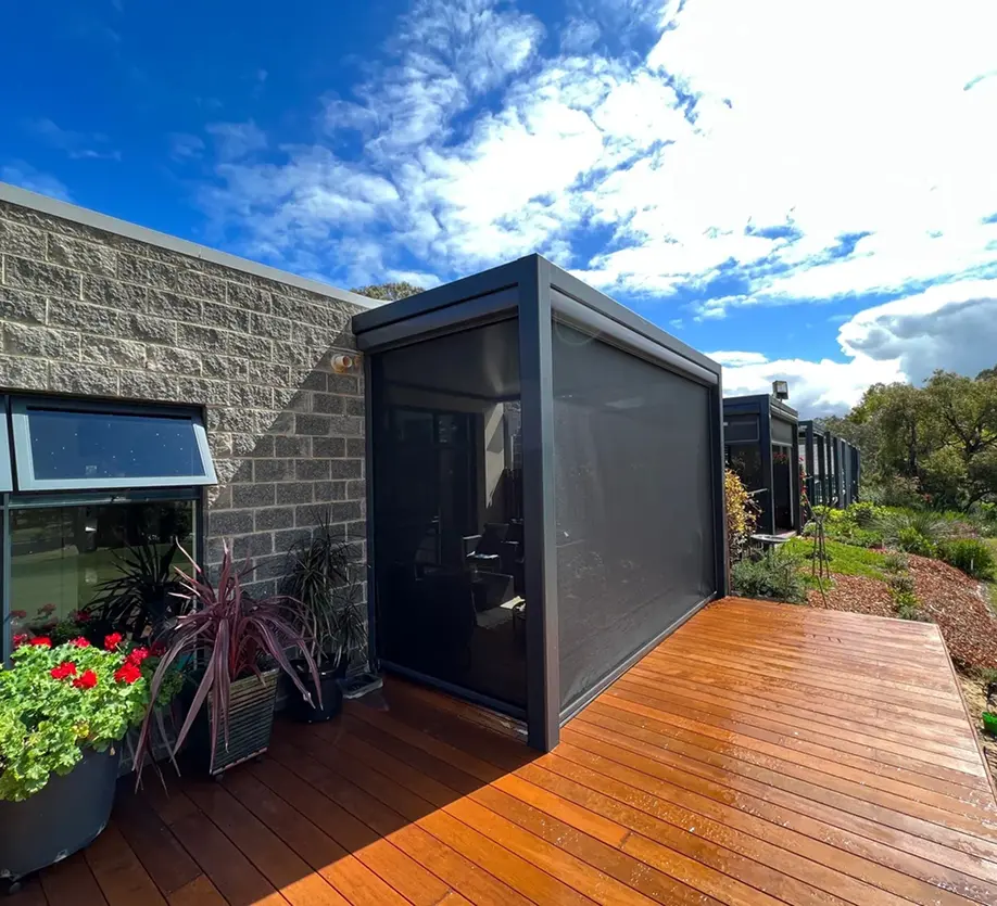Modern house with wooden deck and greenery.